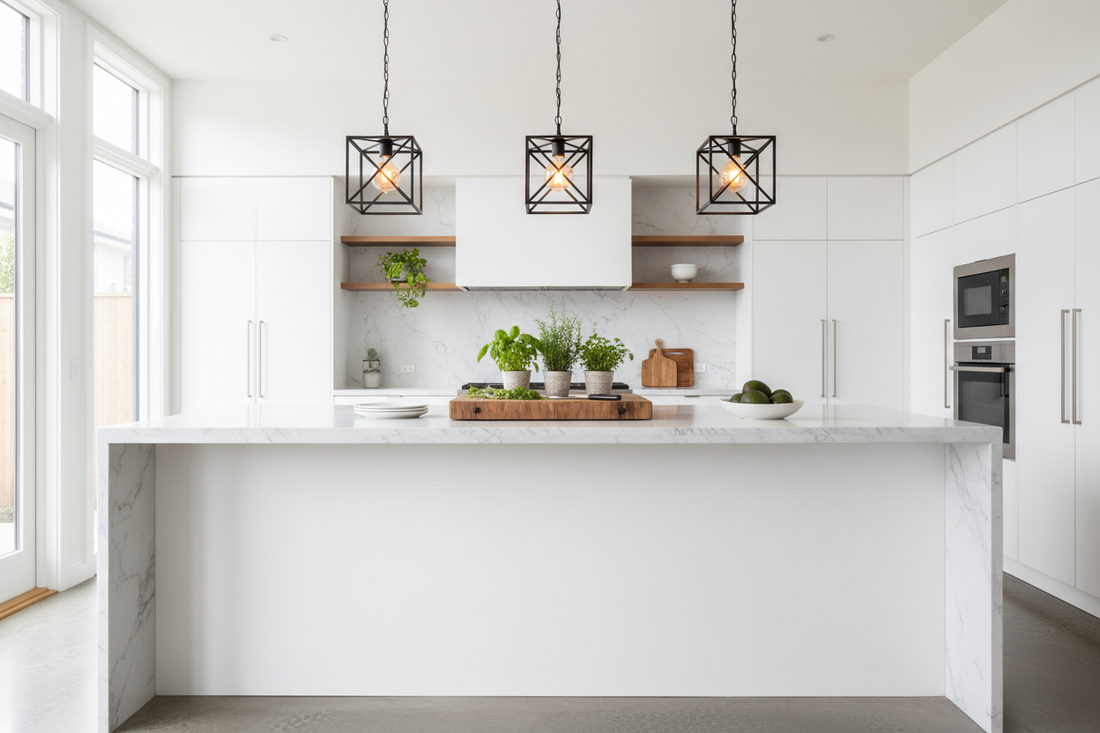 Three matte black square pendant lights hanging over a modern white kitchen island